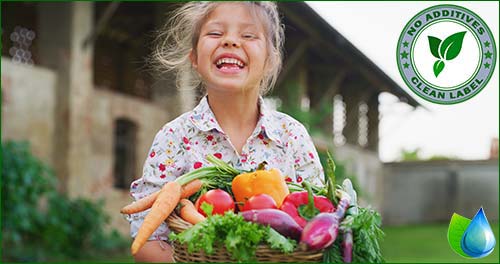 Szcześliwa dziewczynka z koszem ważyw i owoców